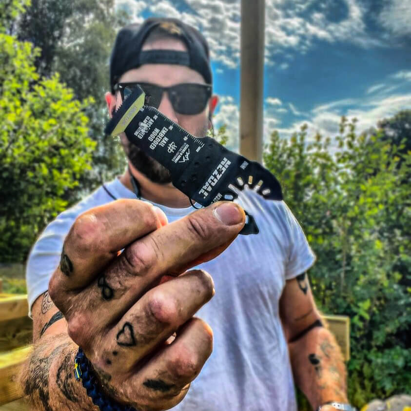 carpenter holding a multi-tool blade in his hand